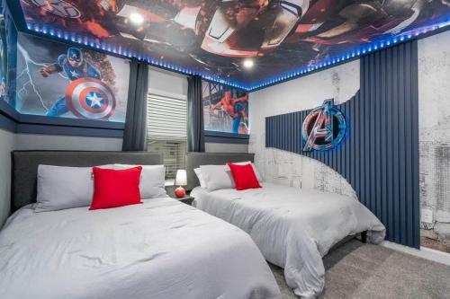 two beds in a room with superheroes on the walls at Stunning 5 Bd w Pool at Storey Lake Resort 2400 in Kissimmee