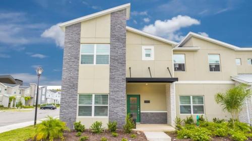 a large house with a green door at Stunning 5 Bd w Pool at Storey Lake Resort 2400 in Kissimmee