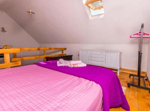 a bedroom with a bed with a purple blanket at Holiday home Kuzmino in Primošten