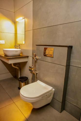 a bathroom with a white toilet and a sink at Jotham Gardens in Alleppey