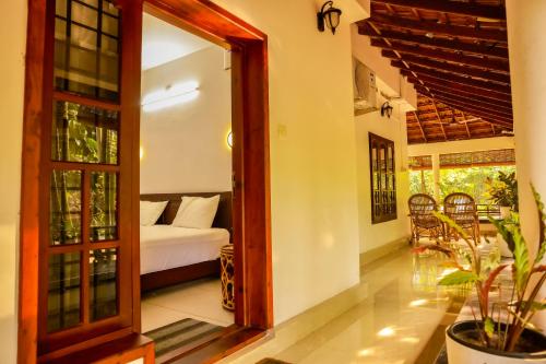 a room with a bed and a room with a window at Jotham Gardens in Alleppey