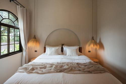 a bedroom with a large white bed with two pillows at Botanica Villas Koh Chang by Indie Beach in Ban Khlong Kloi