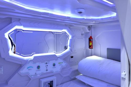 a white room with a bed and a mirror at Kalion Capsule and Boutique Hotel in Almaty