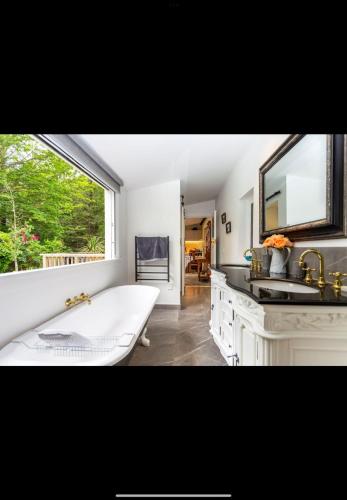 a bathroom with a large bath tub and a window at The old shearers quarters in Glentunnel