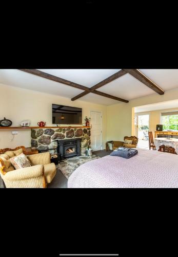 a bedroom with a bed and a stone fireplace at The old shearers quarters in Glentunnel