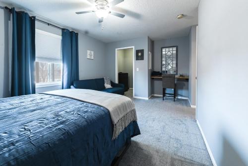 a bedroom with a blue bed and a blue couch at Heart & HomeStay in Ankeny