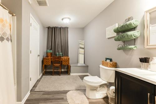 a bathroom with a toilet and a sink and a desk at Heart & HomeStay in Ankeny