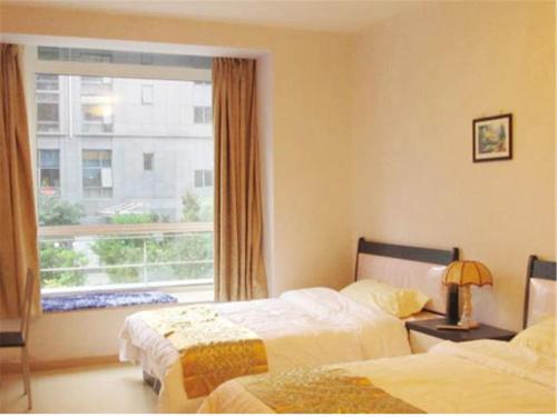 Habitación de hotel con 2 camas y ventana en Beijing Futon Family Apartment, en Beijing