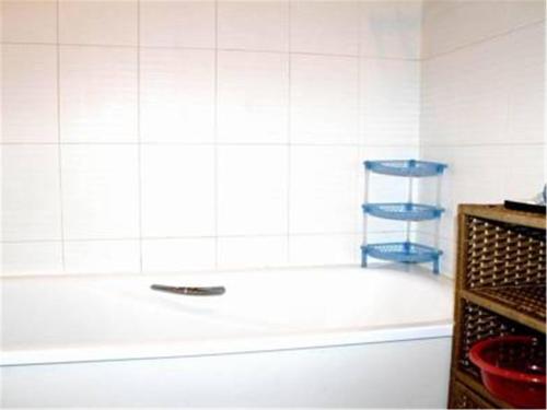 a bathroom with a white tub and a blue chair at Beijing Futon Family Apartment in Beijing