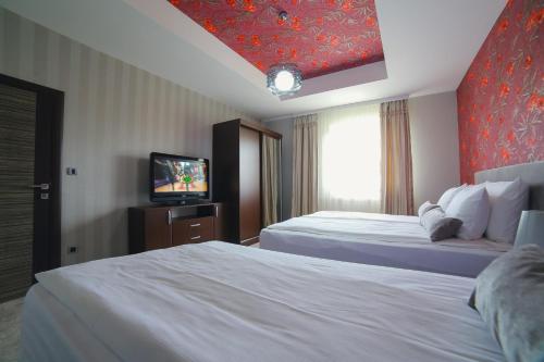 a hotel room with two beds and a television at Garni Hotel Radović in Kragujevac