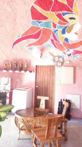 a dining room with a table and a painting on the wall at Kenting Ha-Bi Star Fort in Hengchun