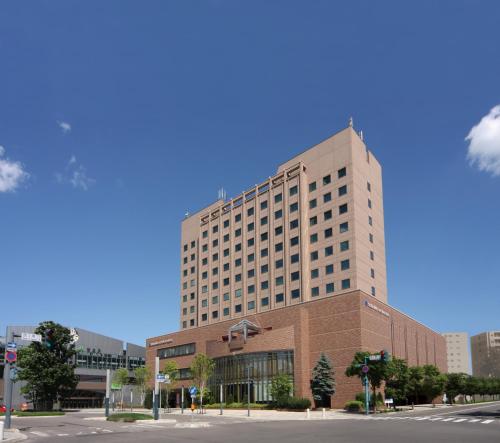 ein hohes Gebäude mit einer Straße davor in der Unterkunft Hotel Nikko Northland Obihiro in Obihiro
