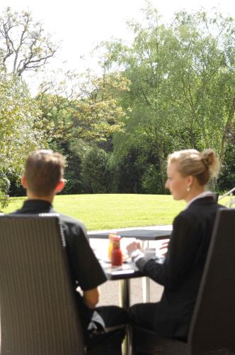 a man and a woman sitting at a table at Logis Hotel, restaurant et spa Le Relais De Broceliande in Paimpont
