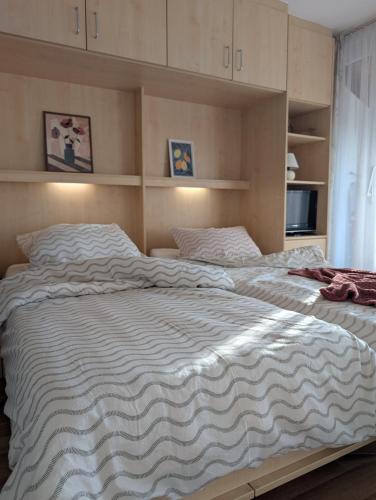 a large bed with a striped blanket on it at Modernes Appartement - ruhig, zentrumsnah, abendsonnige Loggia in Bad Füssing