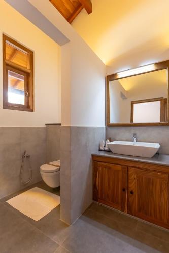 a bathroom with a sink and a toilet and a mirror at Villa Bentota B24 in Bentota