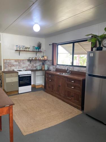 a kitchen with a sink and a refrigerator at Urunga Fisherman's Cottage - pets ok 15 mins Coffs in Urunga