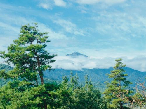 a view of a mountain with trees and clouds at BLANC yatsugatake 2026年4月24日グランドオープン in Hokuto
