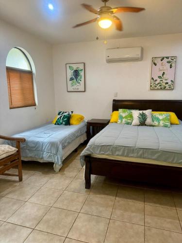 a bedroom with two beds and a ceiling fan at Tama Magico in Tamarindo