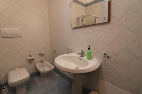 a bathroom with a sink and a toilet and a mirror at Casa Federica Otranto Near Beach & Center AC, WiFi & 6 Sleeps in Otranto