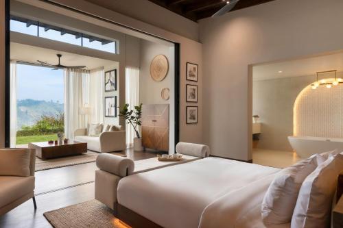 a bedroom with a large bed and a living room at Uga Ghiri - Ella - All Inclusive in Ella