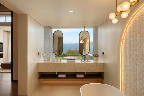 a bathroom with two sinks and a large mirror at Uga Ghiri - Ella - All Inclusive in Ella