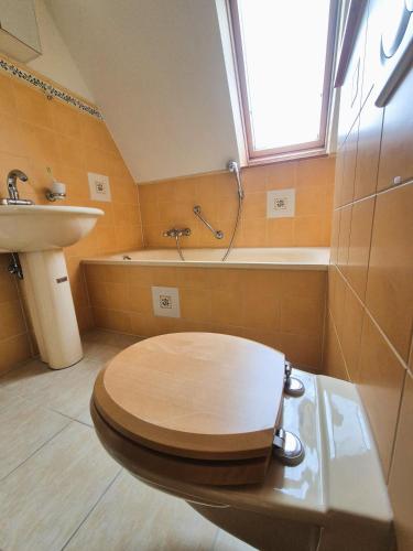 a bathroom with a wooden toilet and a sink at Nordlandgiebel in Rosengarten