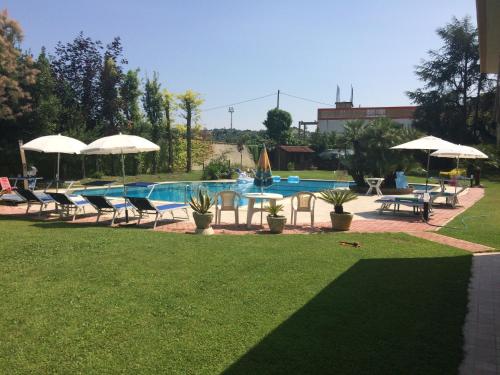 a pool with tables and chairs and umbrellas at B&B Villa Maria in Montesilvano