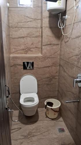 a small bathroom with a toilet and a sink at Sun Hill Homestay in Siliguri