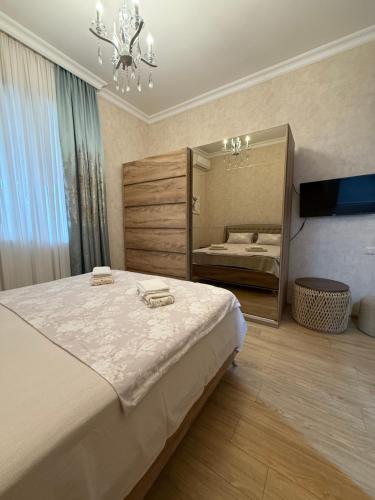a bedroom with a large bed and a mirror at nino hotel in Kobuleti