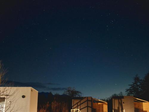 a starry night with two buildings in the foreground at BLANC yatsugatake 2026年4月24日グランドオープン in Hokuto