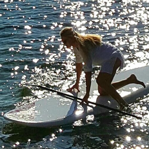 a woman on a paddle board in the water at Rooms Villa Harmonie - Adults Only +14 in Crikvenica