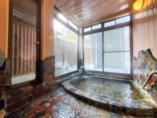 a hot tub in a room with a window at 横磐梯リロード in Inawashiro