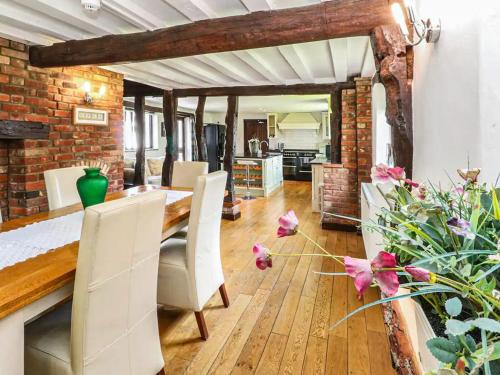 a dining room with a table and chairs and a brick wall at The Farmhouse - Uk48228 in Tibenham
