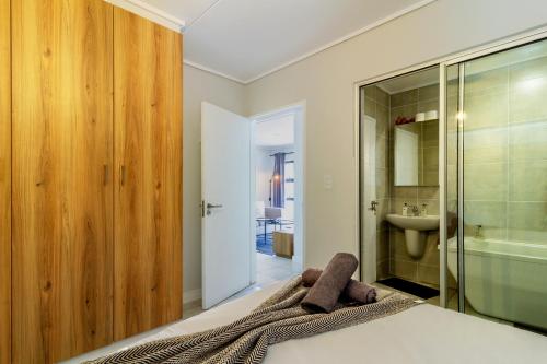 a bedroom with a bed and a shower and a sink at #Alimama Spaces The Future at Greenlee in Sandton