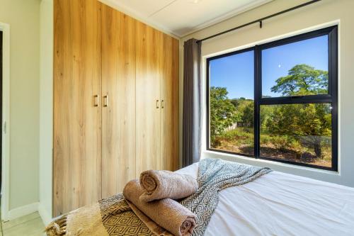 a bedroom with a bed with a large window at #Alimama Spaces The Future at Greenlee in Sandton