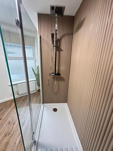 a shower with a glass door in a bathroom at Comfortable 2-Bedroom Coastal Getaway, Sleeps 5 in Great Yarmouth