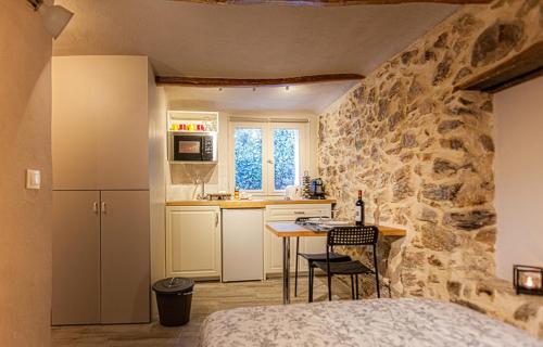 1 dormitorio con pared de piedra y cocina con mesa en Studio Suquet Saint Antoine, en Cannes