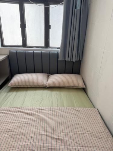 a room with two beds and two windows at 旅居2wubin in Hong Kong