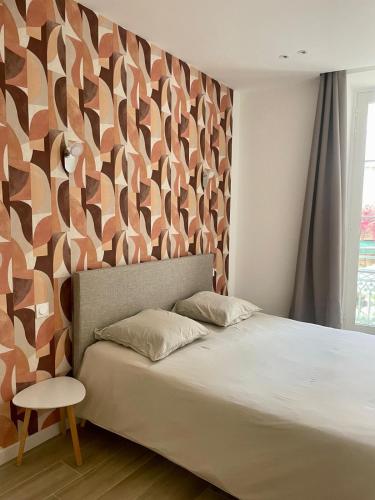 a bedroom with a bed and a wall with a pattern at Chez Jo Fayence in Fayence