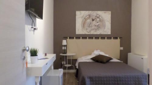 una camera con letto, scrivania e lavandino di B&B Bruna a Firenze