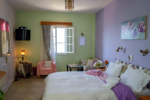 a bedroom with a large bed and a living room at Melina's sunset-Cozy studio with amazing sea view and sunset in Myrties