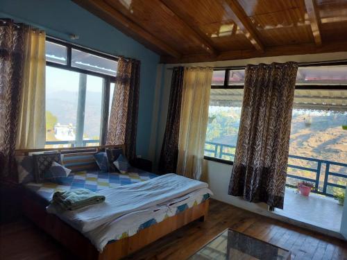 a bedroom with a bed and two large windows at Nirvana Heights Kasar Devi in Hawālbāgh