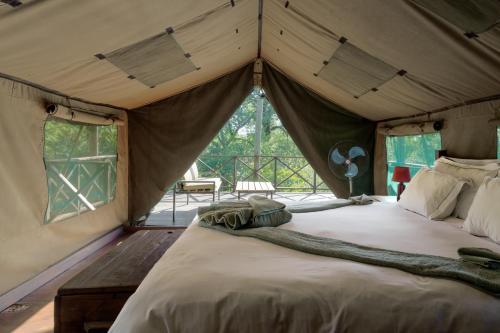 a bedroom with a bed in a tent at Kelora Bush Camp in Hoedspruit