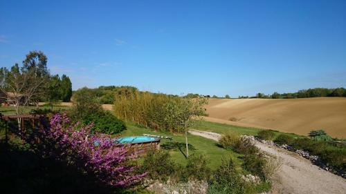 a garden with a pool in the middle of a field at La Grande Oasis - B&B et Spa in Grazac