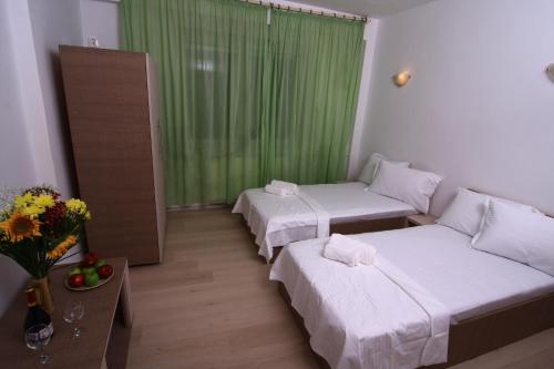 ブカレストにあるBucharest Last Minute Accommodationのベッド2台と緑のカーテンが備わる客室です。