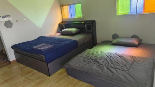 two twin beds in a room with at Thung Setthi Homestay&Cafe4 in Chiang Dao
