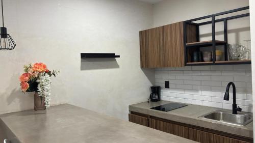 a kitchen with a vase of flowers on a counter at Suites Oros in Oaxaca City