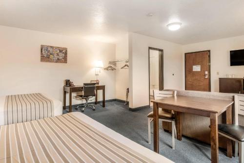 a hotel room with a desk and a bedroom at Econo Lodge Corvallis Near University in Corvallis