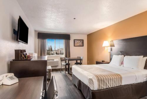 a hotel room with a bed and a desk with a phone at Econo Lodge Corvallis Near University in Corvallis