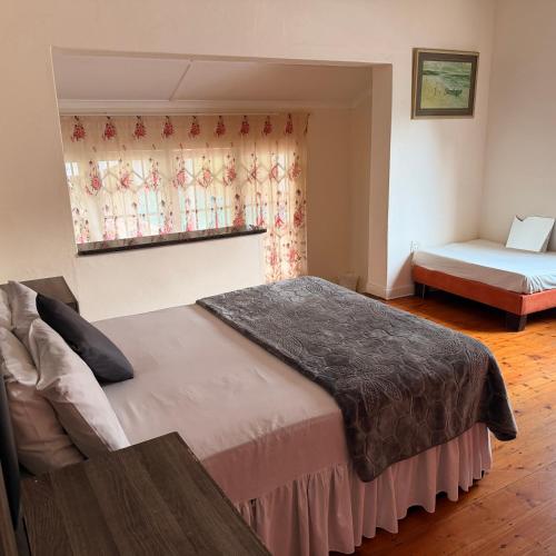 a bedroom with two beds and a window at Eagles Enest BnB in Pietermaritzburg